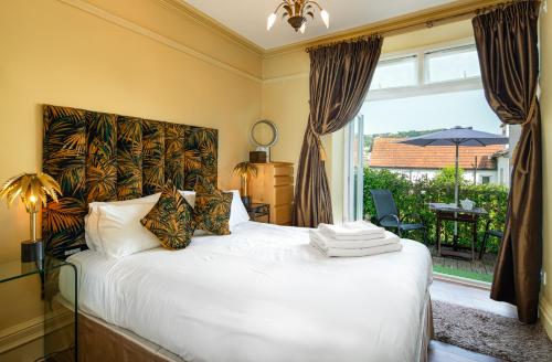 a bedroom with a bed and a large window at Westwood Guest House - Room Only in Lyme Regis