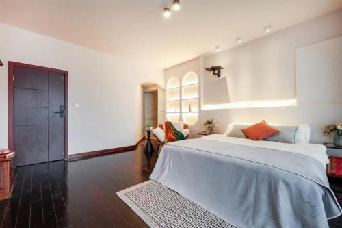 a bedroom with a large white bed in a room at Baihong Riverview Apartment-Hongya Cave in Chongqing
