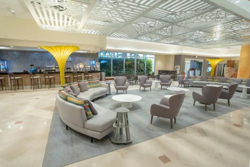 a lobby with couches and chairs and a bar at Courtyard by Marriott Isla Verde Beach Resort in San Juan