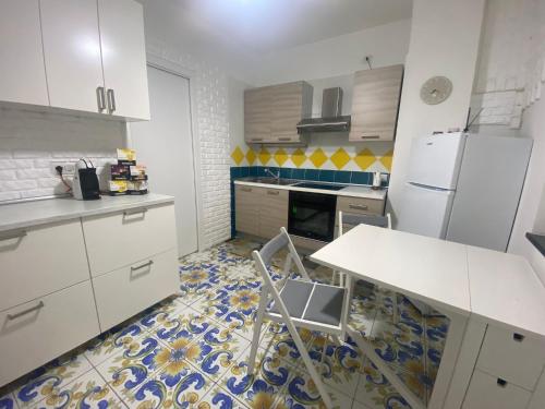 eine Küche mit weißen Schränken und Fliesenboden in der Unterkunft Il Borgo in Sant'Egidio del Monte Albino