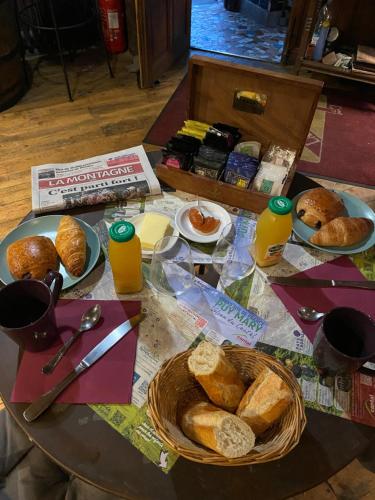 a table topped with plates of bread and orange juice at Charmant appartement au cœur des volcans d Auvergne in Murat