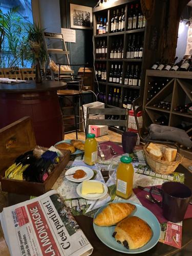 a table with plates of bread and bottles of juice at Charmant appartement au cœur des volcans d Auvergne in Murat
