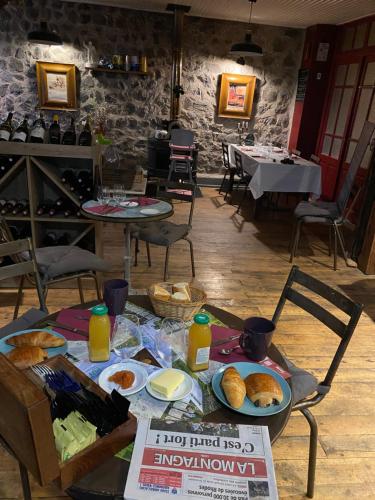 a table with plates of food on it in a restaurant at Charmant appartement au cœur des volcans d Auvergne in Murat