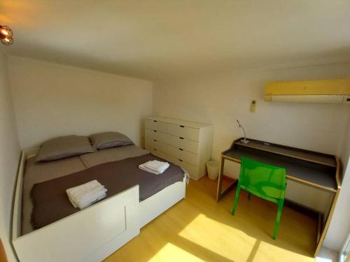 a small bedroom with a bed and a green chair at Casa Grande Abrunheiro Grande in Vila de Rei