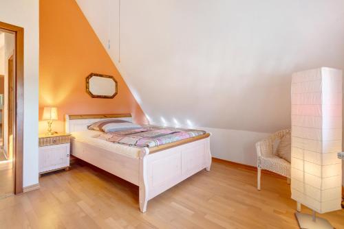 een kleine slaapkamer met een bed en een stoel bij Ferienwohnung im Grünen in Bissendorf