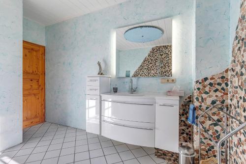 een badkamer met een wastafel en een spiegel bij Ferienwohnung im Grünen in Bissendorf