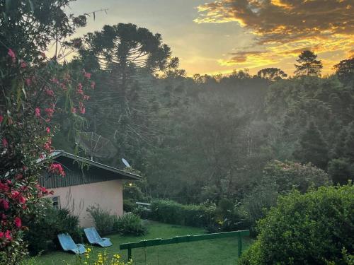 vista de uma casa num jardim ao pôr-do-sol em Casa em Campos do Jordão - 3 quartos, com churrasqueira em Campos de Jordão