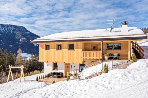 a house on top of a snow covered mountain at Apartments Milanhof in Ortisei