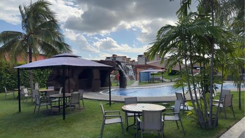 a patio with tables and chairs next to a pool at Eurobuilding Express Barinas in Barinas