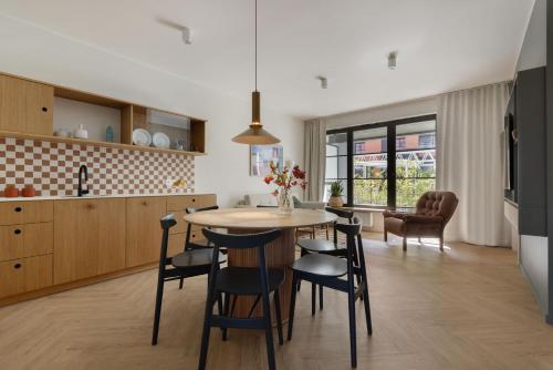 a kitchen and dining room with a table and chairs at Solidarność Three Bedroom & Garden Apartment in Gdańsk