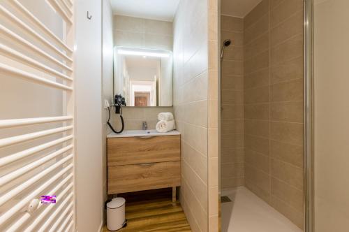 La salle de bains est pourvue d'un lavabo et d'une douche. dans l'établissement MY HOTEL Residences, à La Grande Motte