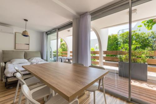 uma sala de jantar com uma mesa de madeira e cadeiras em MY HOTEL Residences em La Grande-Motte