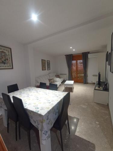 sala de estar con mesa, sillas y sofá en Casa Rosa, en Alcañiz