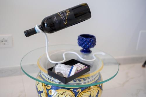 eine Flasche Wein auf einem Glastisch in der Unterkunft U Scrusciu d’u Mari Luxury Suite in Cefalú