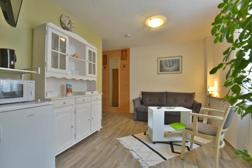 a kitchen and living room with a couch and a table at Pension Bergstube in Bad Langensalza