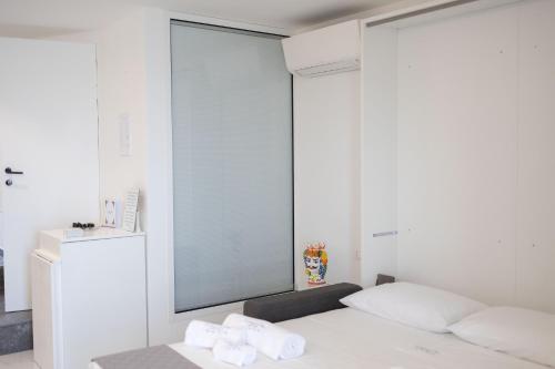 a bedroom with a bed with towels on it at U Scrusciu d’u Mari Luxury Suite in Cefalù