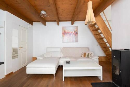 een woonkamer met een witte bank en een tv bij Cozy 3 story house in Old Town in Tallinn