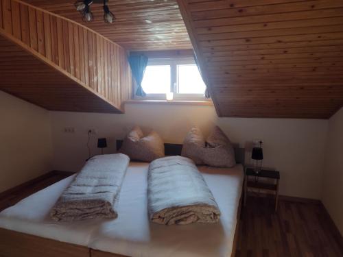 a bedroom with a bed with two pillows and a window at Jochelerhof in Strass im Zillertal
