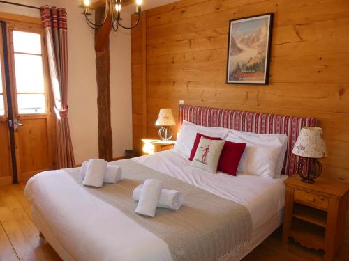 ein Schlafzimmer mit einem großen Bett mit Handtüchern darauf in der Unterkunft La Chaumiere - Luxury Traditional Chalet, Châtel in Châtel