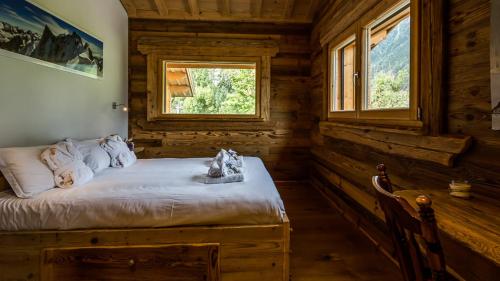 a bedroom with a bed in a log cabin at Chalet Chal'heureux + Annexe in Chamonix-Mont-Blanc
