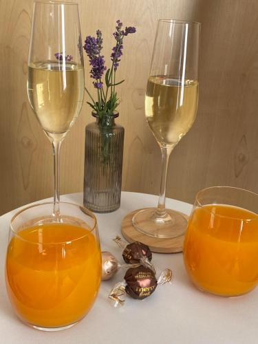 two glasses of white wine and a vase with flowers at Eifel-Mosel-Hideaway in Landscheid