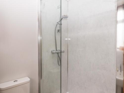 una doccia con porta in vetro in bagno di Mabel's View a Totnes