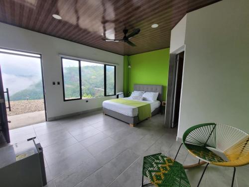 a bedroom with a bed and a green wall at AVANI Boutique Hotel in Norcasia