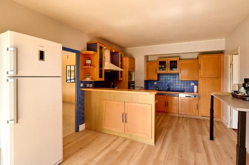 a kitchen with wooden cabinets and a white refrigerator at Superbe Villa avec piscine in Magny-Cours