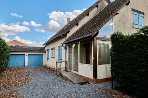 a house with a porch and a garage at Superbe Villa avec piscine in Magny-Cours