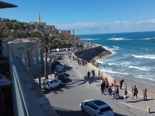 uma multidão de pessoas caminhando ao longo de uma praia em ביקתה בים em Tel Aviv