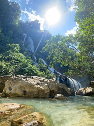 a waterfall in the middle of a river with trees at Sumba Retreat Kerewe in Waikabubak