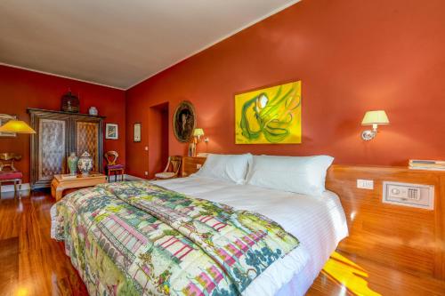 a bedroom with a large bed and orange walls at Relais Villino Rubini in Brunate