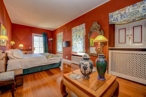 a bedroom with a bed and a table with vases on it at Relais Villino Rubini in Brunate