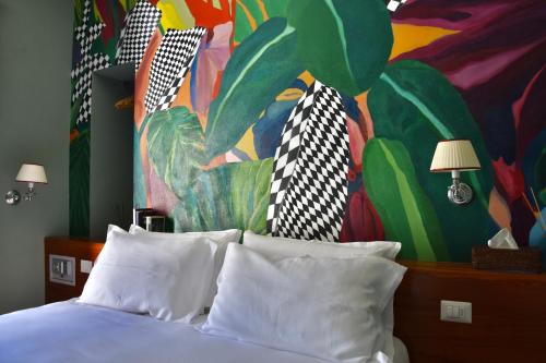 a bedroom with a bed with a painting on the wall at Relais Villino Rubini in Brunate