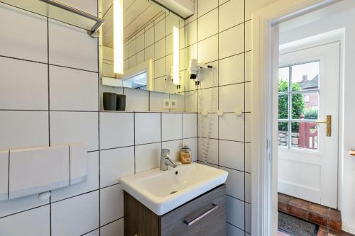 a bathroom with a sink and a mirror at Skriiwers Hüüs in Alkersum