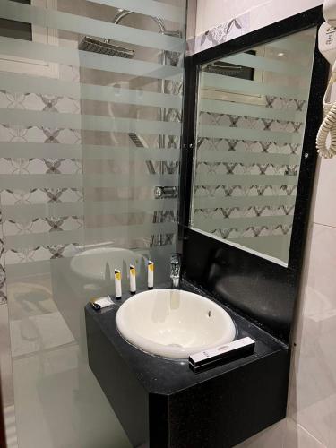فندق ذكرى الكوثر في الطائف: حمام مع حوض ومرآة