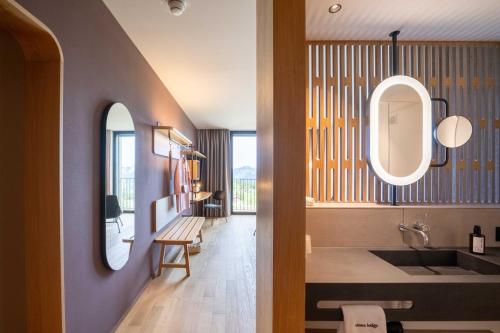 een badkamer met een wastafel en een spiegel bij Stoos Lodge in Stoos