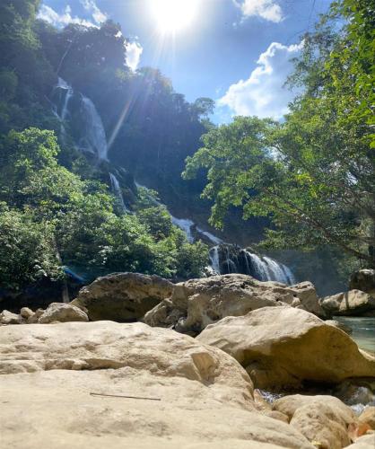 a waterfall in the middle of a river with trees at Sumba Retreat Kerewe in Waikabubak