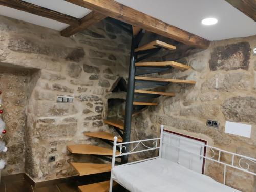 um quarto com uma escada numa parede de pedra em Casa al lado del mar em Vilagarcía de Arousa
