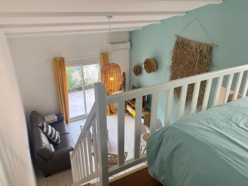a bedroom with a bed and a staircase with a chair at Appartement de standing avec terrasse in Saintes-Maries-de-la-Mer