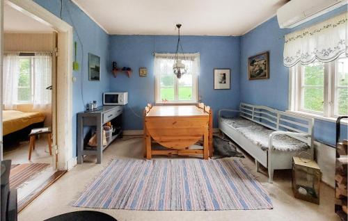 a bedroom with blue walls and a bed and a desk at Stunning Home In Vinslv With Kitchen in Vinslöv
