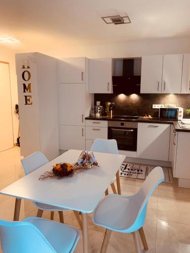 a kitchen with a white table and blue chairs at Ferienwohnung-Weinstadt UG in Weinstadt