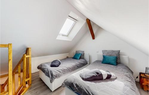 une chambre mansardée avec deux lits et une fenêtre dans l'établissement Lovely Apartment In Neuilly Le Vendin, à Neuilly-le-Vendin