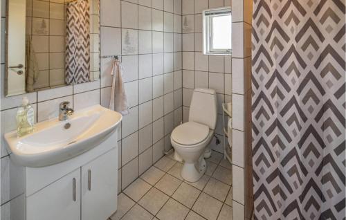 a bathroom with a white sink and a toilet at Nice Home In Lkken With 3 Bedrooms And Wifi in Grønhøj