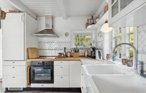 a white kitchen with a sink and a stove at 3 Bedroom Awesome Home In Tranekær in Tranekær