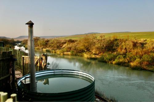 a bath tub sitting next to a river at Tugela River Lodge in Winterton