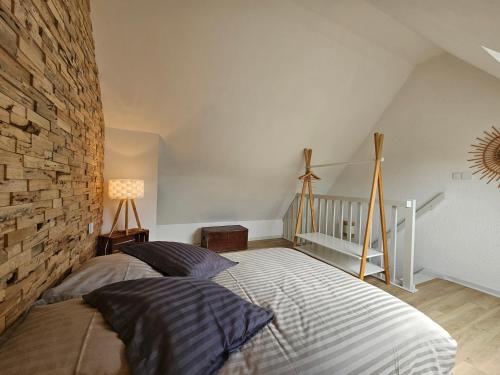 a bedroom with a bed and a brick wall at Duplex T2 terrasse piscine chauffée in Boersch