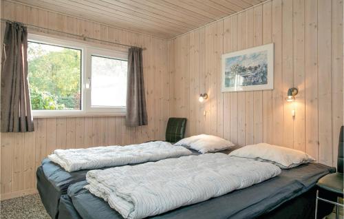HelberskovにあるAmazing Home In Hadsund With 4 Bedrooms, Sauna And Wifiの窓付きの客室で、大型ベッド2台が備わります。