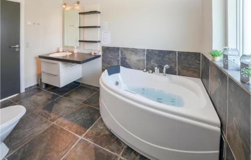 uma casa de banho com uma banheira grande e um lavatório em 3 Bedroom Awesome Home In Sydals em Skovby