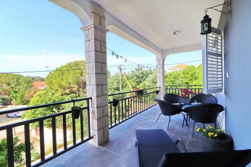 a patio with chairs and a balcony with a view at Apartment Marjana Prižba in Prizba
